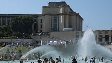 Người dân giải nhiệt tại một đài phun nước ở Paris ngày 26/6. (Ảnh: THX/TTXVN)