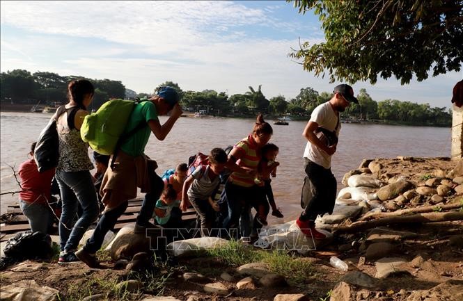 Người di cư từ Tecun Uman (Guatemala) tới Ciudad Hidalgo, bang Chiapas (Mexico) trong hành trình tới Mỹ ngày 14/6. Ảnh: AFP/TTXVN