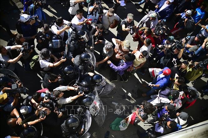 Cảnh sát ngăn chặn người di cư trong hành trình tới Mỹ tại Tijuana, bang Baja California, gần cửa khẩu El Chaparral ở biên giới Mỹ - Mexico, ngày 25/11/2018. Ảnh: AFP/TTXVN