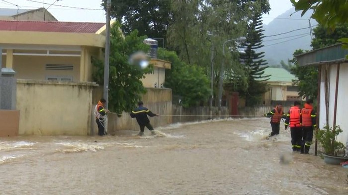 Lực lượng chức năng huyện Mộc Châu, tỉnh Sơn La chăng dây chắn ngang đường ở khu vực bị ngập sâu để cảnh báo và giúp người dân đi lại. (Ảnh: Nguyễn Cường/TTXVN)