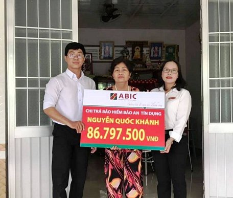 Đại diện ABIC và Agribank Hòa Phú trao biểu trưng chi trả bảo hiểm cho gia đình khách hàng.