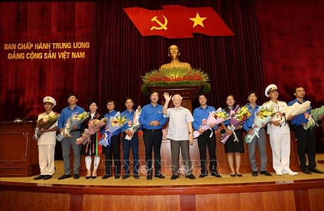 Tổng Bí thư, Chủ tịch nước Nguyễn Phú Trọng tặng hoa các đảng viên trẻ tiêu biểu. (Ảnh: TTXVN)