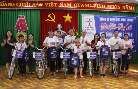 Ông Nguyễn Công Hầu- Phó Tổng Giám đốc Tổng Công ty Điện lực Miền Nam, Giám đốc Công ty Điện lực Vĩnh Long (thứ 5 từ phải sang) trao xe đạp cho các em học sinh.