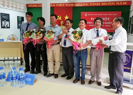 Ông Hứa Văn Chiến- Chủ tịch Hội VHNT (thứ tư từ phải sang) và ông Nguyễn Hòa Bình- Phân Hội trưởng Phân hội Nhiếp ảnh nhiệm kỳ VI (bìa phải) tặng hoa cho ban chấp hành mới.