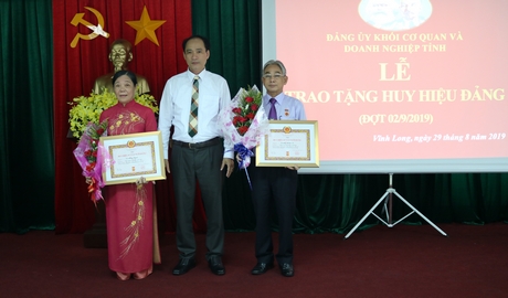 Đồng chí Trần Xuân Thiện- Bí thư Đảng ủy Khối Cơ quan và Doanh nghiệp tỉnh trao tặng Huy hiệu 45 năm tuổi Đảng cho 2 đảng viên.