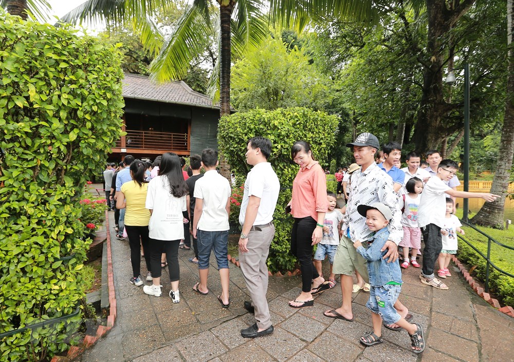  Người dân, du khách đến tham quan Nhà sàn Bác Hồ trong khuôn viên Khu Di tích Chủ tịch Hồ Chí Minh. (Ảnh: Lâm Khánh/TTXVN)