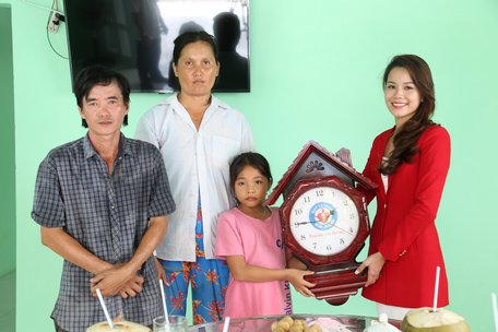Bà Nguyễn Thị Hồng Hạnh (bìa phải) đại diện Quỹ từ thiện Kim Oanh trao nhà cho gia đình ông Ân, người đang nuôi nấng cháu Vy.