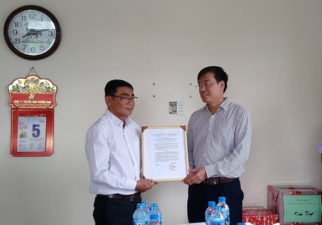Ông Uông Quang Huy- Trưởng Ban chính sách pháp luật Công đoàn Điện lực Việt Nam (bên phải) trao quyết định bàn giao nhà “Mái ấm Công đoàn” cho anh Phạm Hoàng Sa.