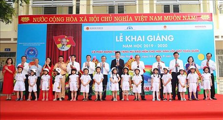 Phó Thủ tướng Thường trực Chính phủ Trương Hòa Bình và các đại biểu tặng mũ cho các cháu lớp 1 trường Tiểu học Hoàng Hoa Thám, thành phố Thanh Hóa. Ảnh: Doãn Tấn/TTXVN