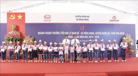 Phó Thủ tướng Vương Đình Huệ trao tặng học bổng cho các em học sinh giỏi nhà trường. Ảnh: Trần Việt/TTXVN