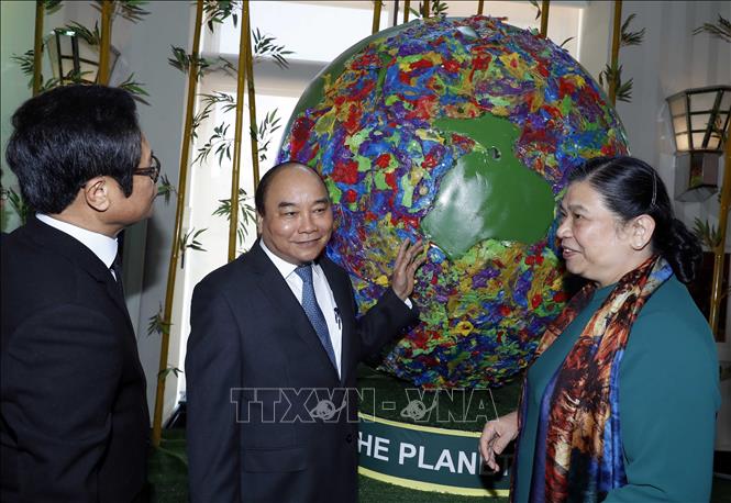  Thủ tướng Nguyễn Xuân Phúc và Phó Chủ tịch thường trực Quốc hội Tòng Thị Phóng bên quả cầu phủ rác thải nhựa - biểu tượng trái đất của chúng ta đang bị rác thải nhựa bao phủ, ảnh hưởng đến sự phát triển bền vững. Ảnh: Thống Nhất/TTXVN