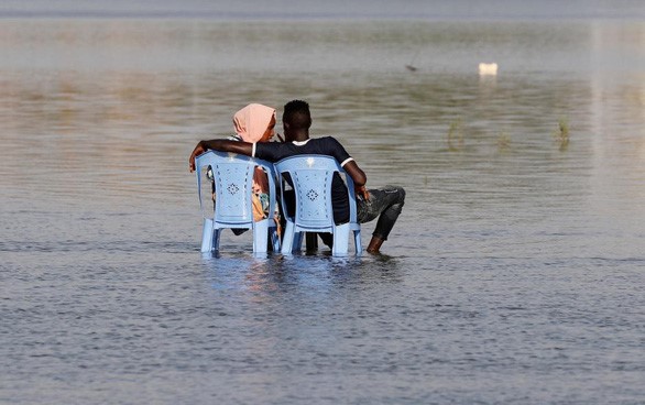 Cặp đôi người Sudan ngồi trên một nhánh sông Nile khi triều xuống - Ảnh: REUTERS