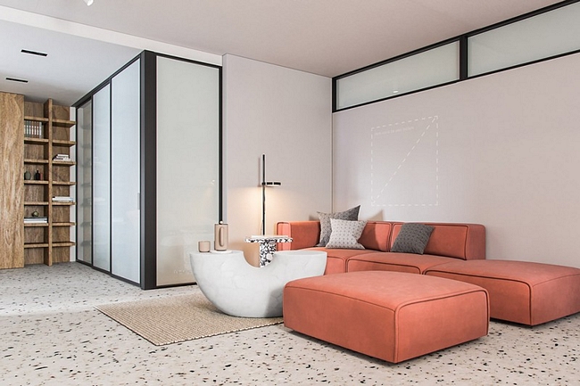 Bắt đầu bước vào căn hộ là phòng khách mở rộng rãi, một ghế sofa dài màu cam nổi bật giữa căn phòng.