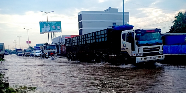 Đường QL1, đoạn qua xã Thuận An bị ngập nặng, gây khó khăn cho người và xe đi qua đây.  