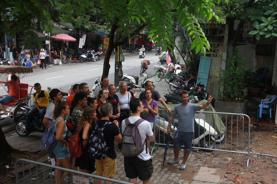 Một nhóm du khách nước ngoài được hướng dẫn viên giới thiệu đến tham quan phố “cà phê đường tàu”.