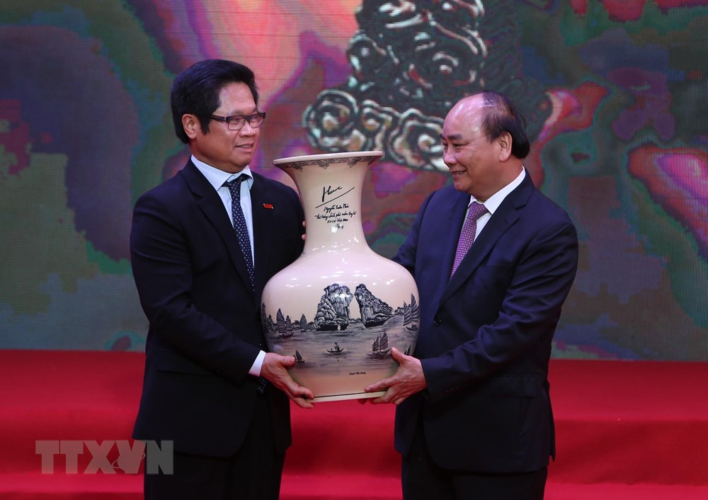  Chủ tịch Phòng Thương mại và Công nghiệp Việt Nam Vũ Tiến Lộc, đại diện các doanh nhân nhận quà tặng của Thủ tướng Nguyễn Xuân Phúc. (Ảnh: Dương Giang/TTXVN)