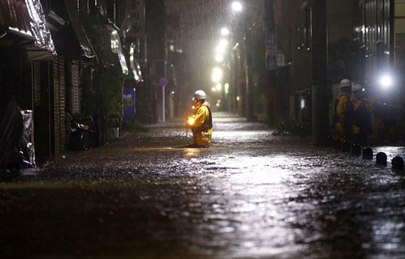 Lính cứu hỏa tuần tra trên một con phố ngập sâu do mưa lớn trong siêu bão Hagibis ở Tokyo - Ảnh: REUTERS