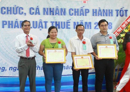 Ông Lê Quang Trung- Phó Chủ tịch Thường trực UBND tỉnh (đứng ở bìa trái) trao bằng khen của Bộ Tài chính cho 3 tổ chức và 1 hộ cá nhân kinh doanh.