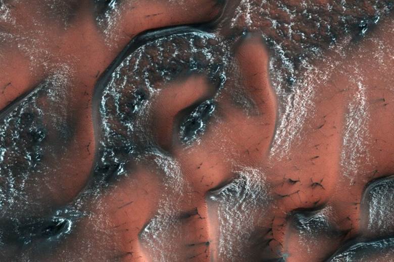 Mùa xuân trên sao Hỏa: Những đụn cát ở bán cầu bắc của sao Hỏa được bao phủ bởi tuyết và băng khô cho tới khi ánh nắng mùa xuân chiếu đến, băng tuyết tan ra để lộ những dải cát tối màu như bức ảnh trên.