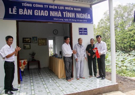  Ông Nguyễn Phước Đức- Tổng Giám đốc Tổng Công ty Điện lực Miền Nam (bìa phải) và chính quyền địa phương trao nhà cho vợ chồng bà Phấn (đứng giữa).
