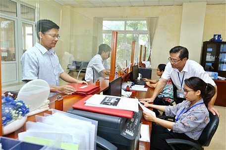 Khách hàng đến giao dịch tại Cục Thuế tỉnh Quảng Bình. Ảnh: Phạm Hậu/TTXVN.