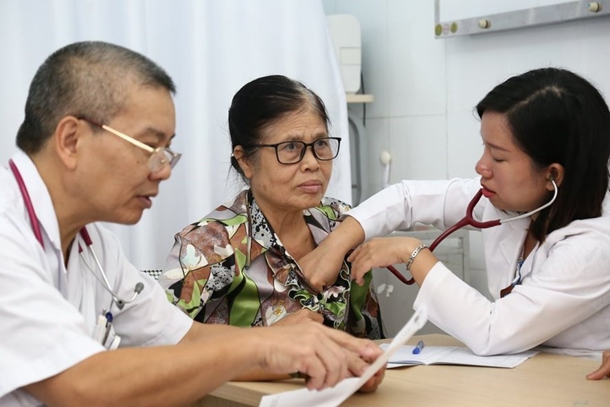 PGS.TS Nguyễn Hữu Ước (bên trái) thăm khám, tư vấn cho người bệnh đến khám bệnh lý mạch vành.