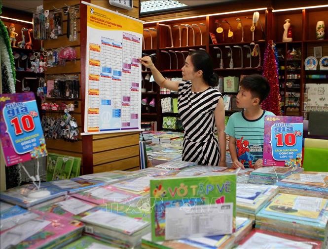 Phụ huynh xem bảng giá niêm yết sách giáo khoa tại cửa hàng thuộc hệ thống phân phối chính thức của NXB Giáo dục Việt Nam. Ảnh: Thanh Tùng/TTXVN