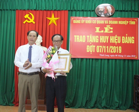 Đồng chí Trần Xuân Thiện- Bí thư Đảng ủy Khối Cơ quan và Doanh nghiệp tỉnh trao tặng Huy hiệu cho đảng viên 40 năm tuổi Đảng.