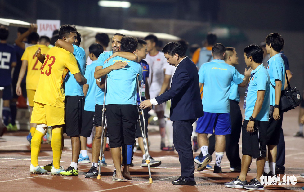 Tổng thư ký VFF Lê Hoài Anh quan tâm đến chấn thương của Kim Nhật khi anh đeo nạng xuống sân chia vui với các đồng đội - Ảnh: N.K