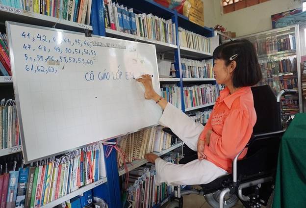  Dù bị liệt hai tay và một chân, nhưng chị Huỳnh Thị Xậm (quê Hậu Giang) đã nỗ lực vượt lên chính mình, trở thành người có ích cho xã hội. Bên cạnh công việc của một nhân viên thư viện tại Trung tâm dạy nghề cho người khuyết tật và trẻ mồ côi Thành phố Hồ Chí Minh, chị còn là một “cô giáo” đặc biệt của những học viên có độ tuổi từ 15 – 35 tuổi nhưng chưa biết chữ. (Ảnh: Thu Hoài/TTXVN)
