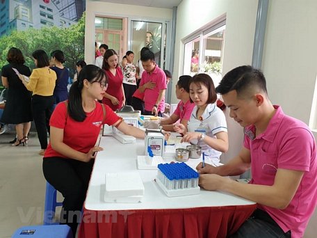  Lấy mẫu máu xét nghiệm cho người hiến máu tình nguyện. (Ảnh: PV/Vietnam+)