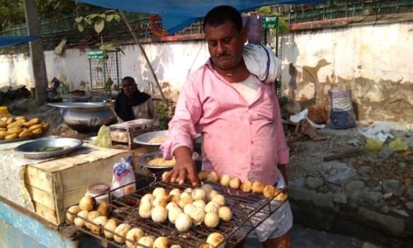 Một người bán hàng rong ở Patna đang nướng bánh litti chokha. Ảnh: The Guardian