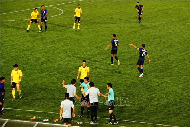  Huấn luyện viên đội U22 Malaysia Ong Kim Swee (áo trắng, trái) phản ứng với trọng tài trong một trận đấu. Ảnh: Nhóm PV TTXVN tại Campuchia