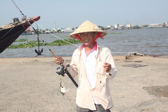 Ông Trần Văn Thoi chạy xe ôm ở bến phà, nhưng giờ câu cá kiếm thêm - Ảnh: T.NHƠN