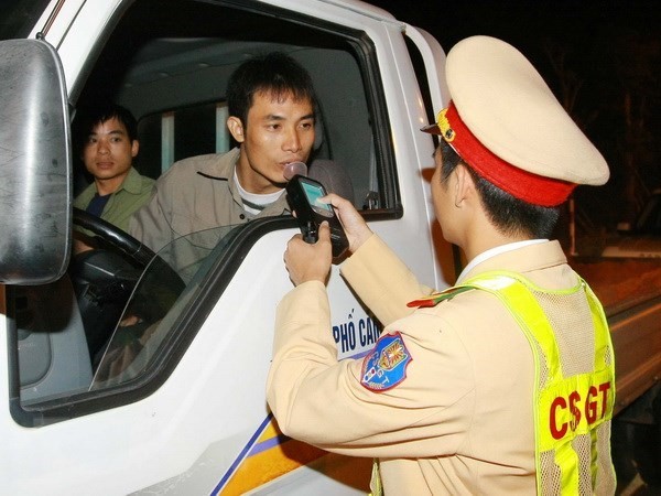 Cảnh sát giao thông kiểm tra nồng độ cồn của lái xe. (Ảnh: Doãn Tấn/TTXVN)