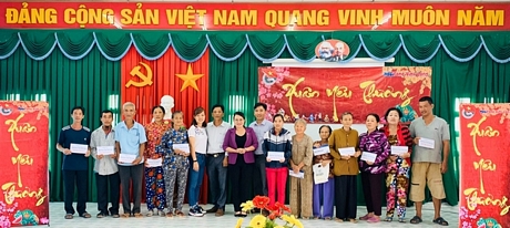 Giám đốc Mibifone tỉnh Vĩnh Long Nguyễn Thị Đoàn (đứng giữa- áo tím) trao quà cho các hộ gia đình tại xã Thuận An.