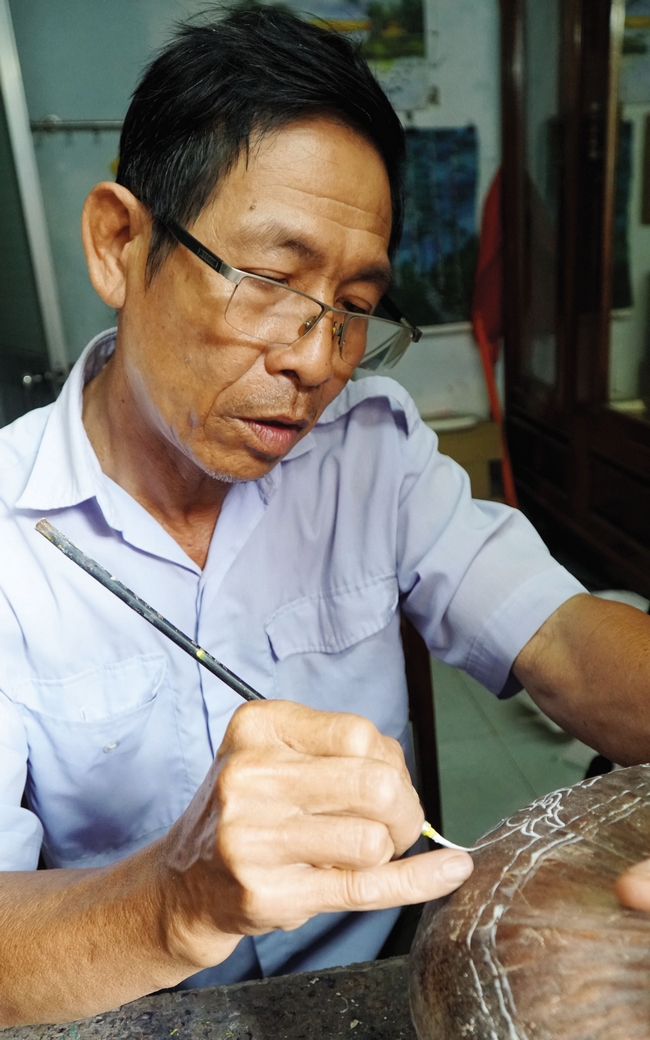 Ông Đặng Hồng Điểm vẽ phác họa hình thù lên vỏ dừa rồi dùng dao khắc, đây là công đoạn chính tạo ra sản phẩm.