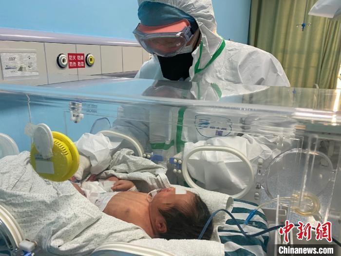 Bác sĩ Tăng Lăng Không khám cho trẻ sơ sinh đang điều trị tại bệnh viện. Ảnh: Chinanews