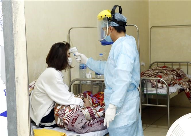 Nhân viên y tế kiểm tra thân nhiệt cho các ca bệnh đang được cách ly theo dõi nCoV tại Trung tâm Y tế Bình Xuyện, tỉnh Vĩnh Phúc (chiều 7/2/2020). Ảnh: Dương Ngọc/TTXVN