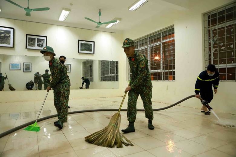 Lực lượng công an, bộ đội dọn vệ sinh các phòng dùng để làm bệnh viện dã chiến. (Ảnh: Hoàng Hùng/TTXVN)