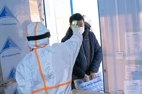 Nhân viên y tế kiểm tra thân nhiệt cho bệnh nhân nhiễm Covid-19 tại một bệnh viện dã chiến ở Vũ Hán, Trung Quốc ngày 5/2/2020. (Nguồn: THX/TTXVN)