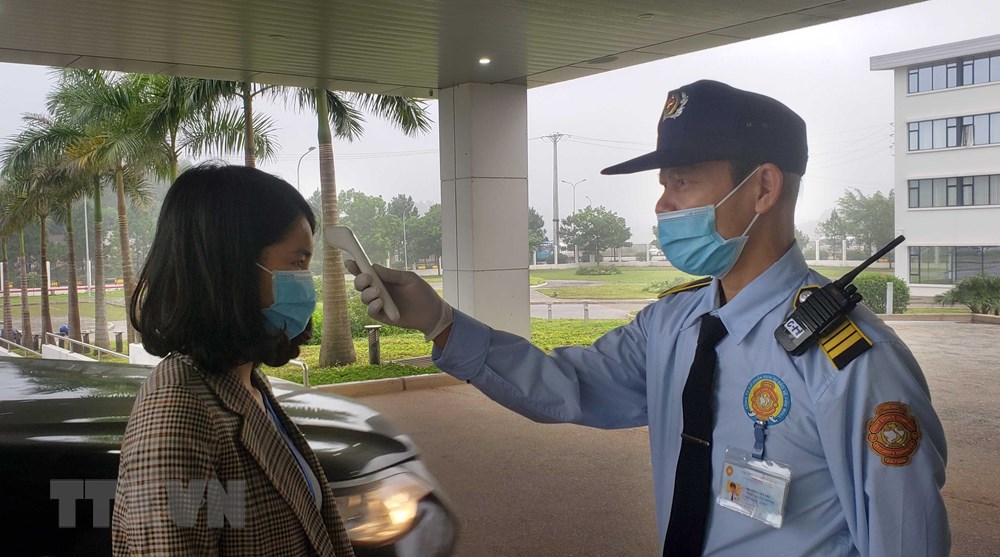  Khách đến làm việc tại các công ty trong Khu công nghiệp Bá Thiện 2, huyện Bình Xuyên được đo kiểm tra thân nhiệt. (Ảnh: Hoàng Hùng/TTXVN)