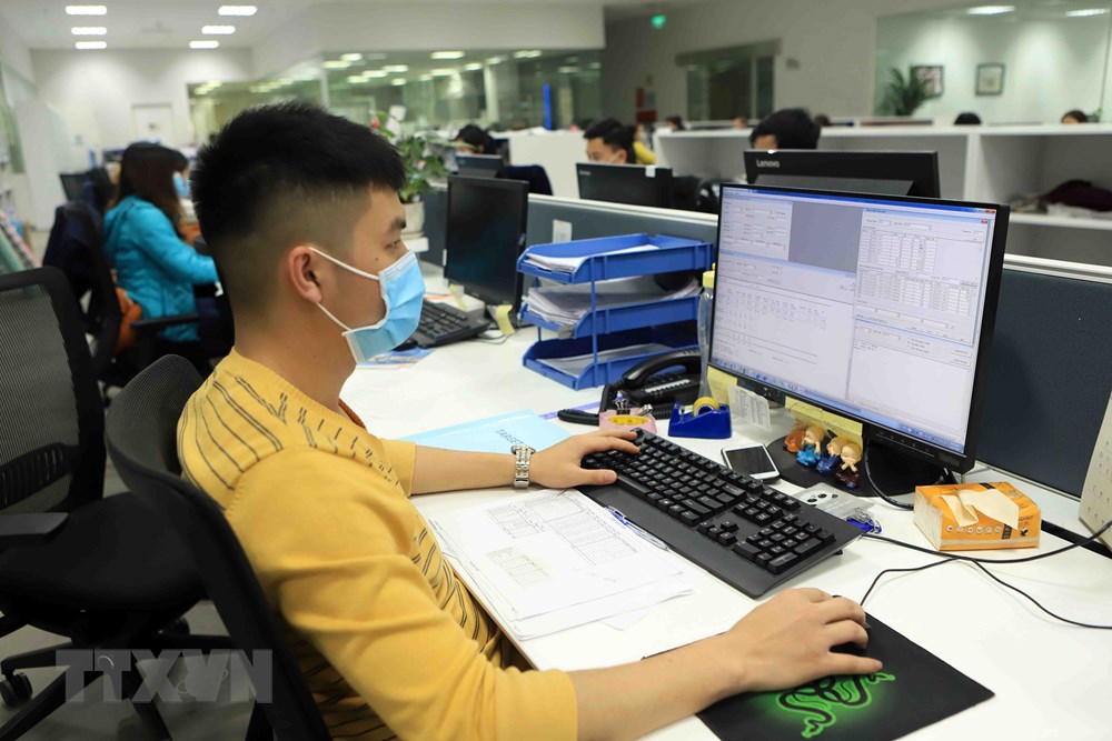  Nhân viên văn phòng Công ty TNHH sản xuất hàng may mặc Việt Nam tại Khu công nghiệp Bá Thiện 2 đeo khẩu trang khi làm việc. (Ảnh: Hoàng Hùng/TTXVN)