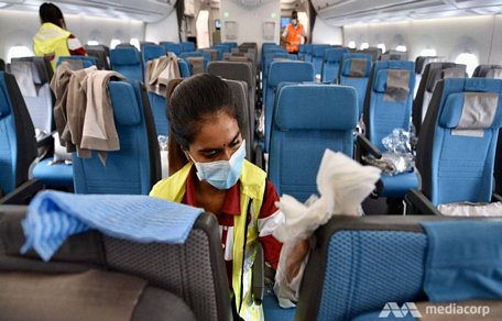 Các nhân viên y tế tiến hành khử trùng trên một chiếc máy bay của Singapore. Ảnh: Mediacorp.