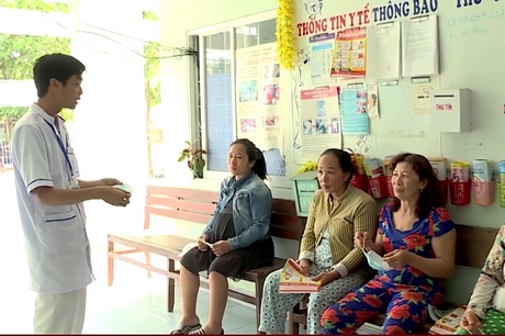 Nhân viên Trạm Y tế xã Song Phú (Tam Bình) hướng dẫn người dân đến khám đeo khẩu trang đúng cách để phòng bệnh.