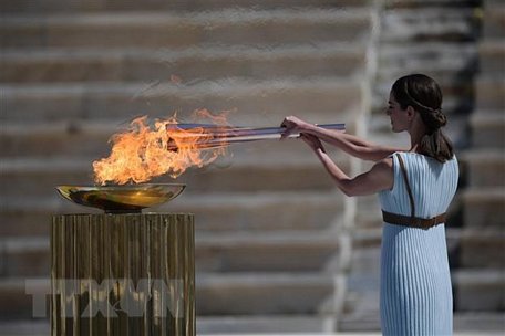 Diễn viên Hy Lạp Xanthi Georgiou thắp ngọn đuốc Olympic trong lễ trao đuốc cho Nhật Bản tại Athens, Hy Lạp, ngày 19/3/2020. Ảnh: AFP/TTXVN
