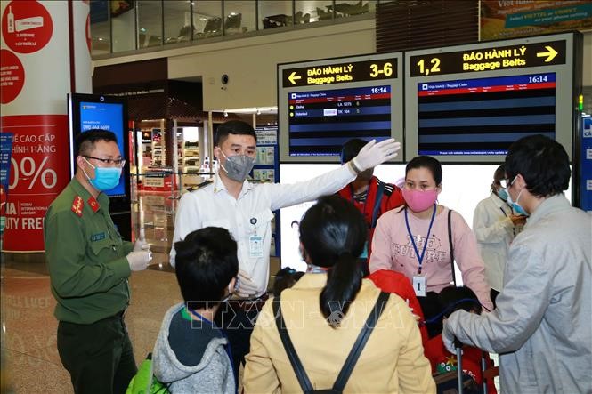 Lực lượng Công an cửa khẩu hướng dẫn hành khách đi cách ly, tại Cảng hàng không quốc tế Nội Bài (Hà Nội). Ảnh: Doãn Tấn/TTXVN
