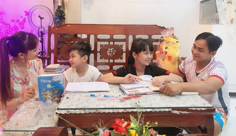 Vợ chồng chị Xuân Lan cùng con ôn bài vở trong thời gian con nghỉ học ở nhà.