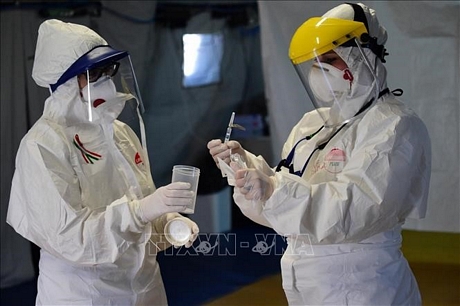Nhân viên y tế kiểm tra thiết bị xét nghiệm phát hiện virus SARS-CoV-2 tại Bologna, Italy ngày 23/3. Ảnh: THX/TTXVN