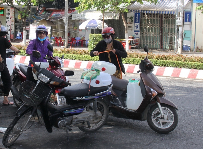 Người dân chở nước về nhà trên đại lộ Đồng Khởi (TP Bến Tre). Nhiều điểm tư nhân cung cấp nước ngọt miễn phí đồng hành cùng chính quyền địa phương chia sẻ với bà con.
